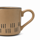 Beige mug with black interior and decorative black lines on a white background