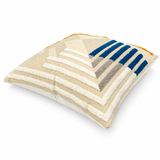 Angled view of textured geometric throw pillow with blue, gray, and cream pattern on a neutral background