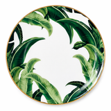 Top view of tropical leaf porcelain dinner plate with gold rim on a clean background, modern elegant tableware design